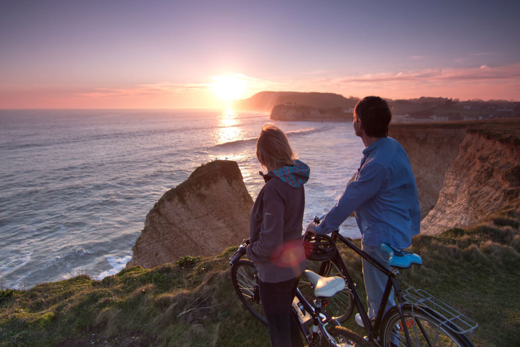 A young family watching the sunset from the cliffs of the Isle of Wight